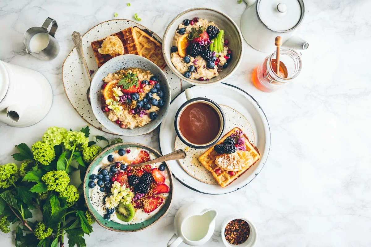 Trois bols de porridge aux fruits rouges, gaufres, caf&eacute;, herbes vertes &mdash; un petit-d&eacute;jeuner soign&eacute;